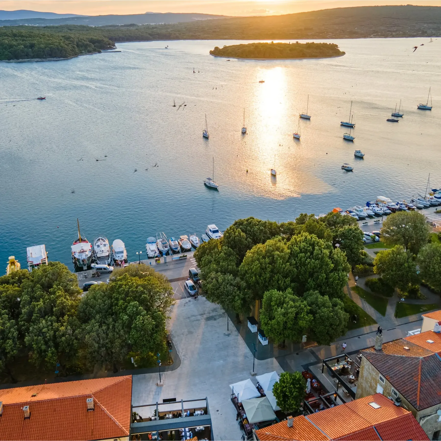 Zračni pogled na luku Punta u suton, s terasama restorana uz obalu